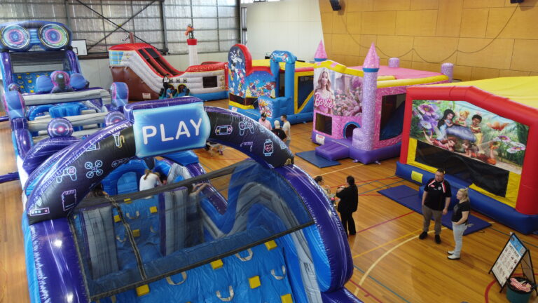 Jumping castle hire setup at indoor event in Koo Wee Rup with multiple inflatables and obstacle courses