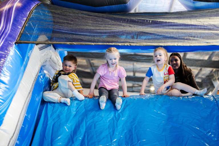 kids playing inside jumping castle sliding and having fun at party hire event in Longwarry
