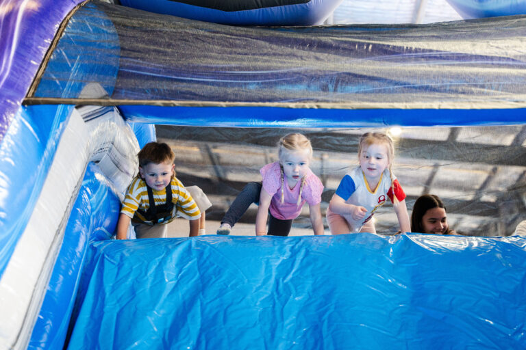 kids playing and sliding inside jumping castle at party hire event in Drouin