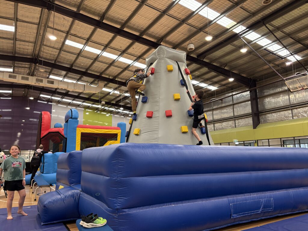 4-player inflatable rock climbing wall for hire in Melbourne with four climbing lanes and inflatable safety base.