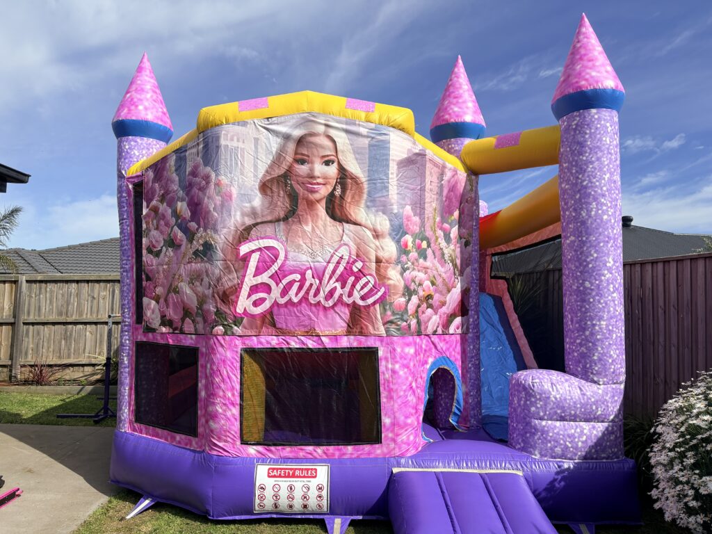 Barbie Glitter Jumping Castle with slide for hire in Melbourne, featuring sparkling pink and purple castle artwork.